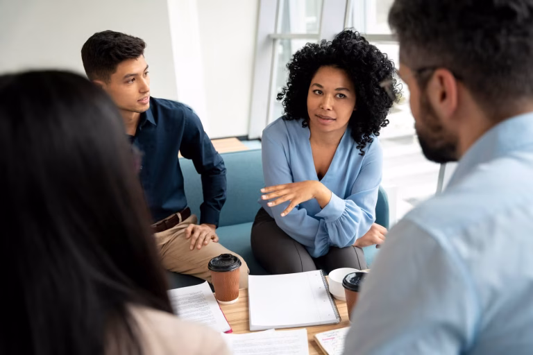 HR team meeting with professionals discussing policies and employee concerns around a table, illustrating proactive HR support